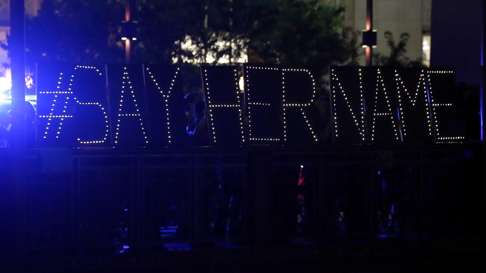 Protesters hold up a lighted sign reading #sayhername during a vigil for Sandra Bland on July 28, 2015 [AP/Christian K. Lee] 