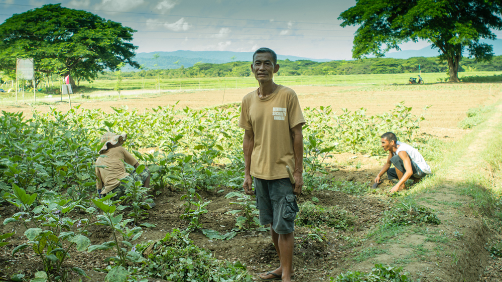 Convicted murderer Oscar Omisol takes care of a vegetable plot inside the colony [Angel L Martinez Cantera/Al Jazeera]