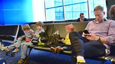 A man and his three children use their smartphones, tablets and other mobile devices [Getty]