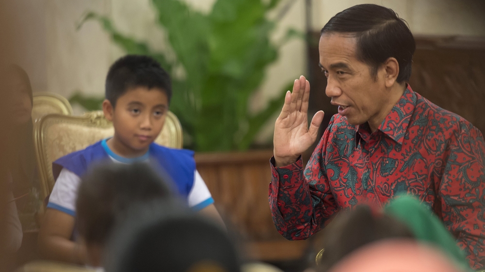 Indonesia President Joko Widodo gestures as he answers questions from representatives of elementary school students, playing the role of young reporters, at the Presidential Palace in Jakarta