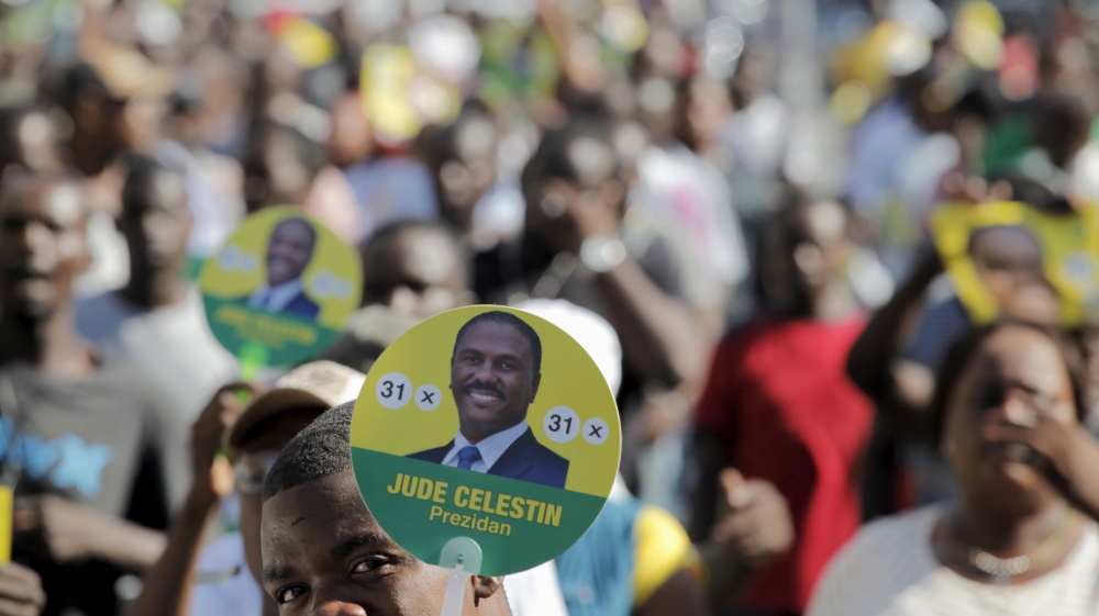 A supporter of presidential candidate Jude Celestin holds a sign during a demonstration to protest against the electoral process in Port-au-Prince, Haiti