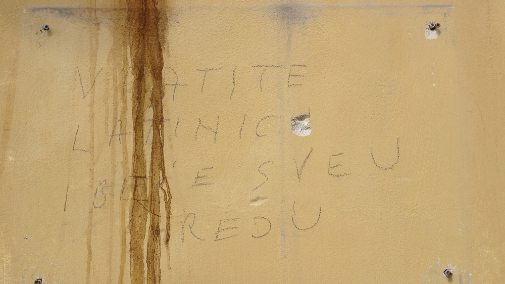 The Cyrillic signs placed around the town have been removed and replaced by handwritten messages[Coen van de Ven/Al Jazeera]