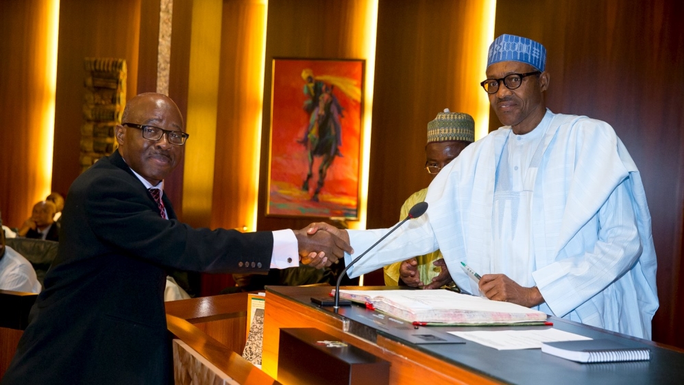 Nigerian President Muhammadu Buhari congratulates INEC National Commissioner Mohammed Mustapha Lecky shortly after his swearing in, in Abuja