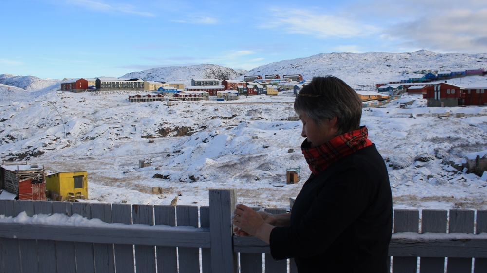 Astrid Olsen makes a snowball from the season's first snow. The winter here will be long, cold and dark [Lene Bech Sillesen/Al Jazeera]