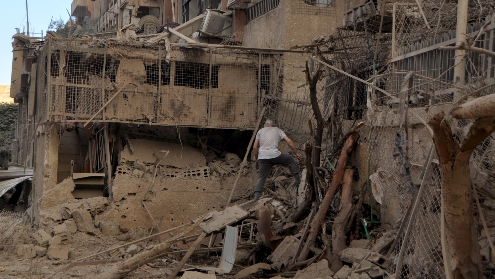 A man walks on debris at a site hit by what activists said were barrel bombs thrown by forces loyal to Syria''s President Bashar Al-Assad, in the Palestinian Yarmouk refugee camp