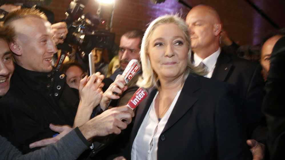 French National Front political party leader and candidate Marine Le Pen is surrounded by media [REUTERS]