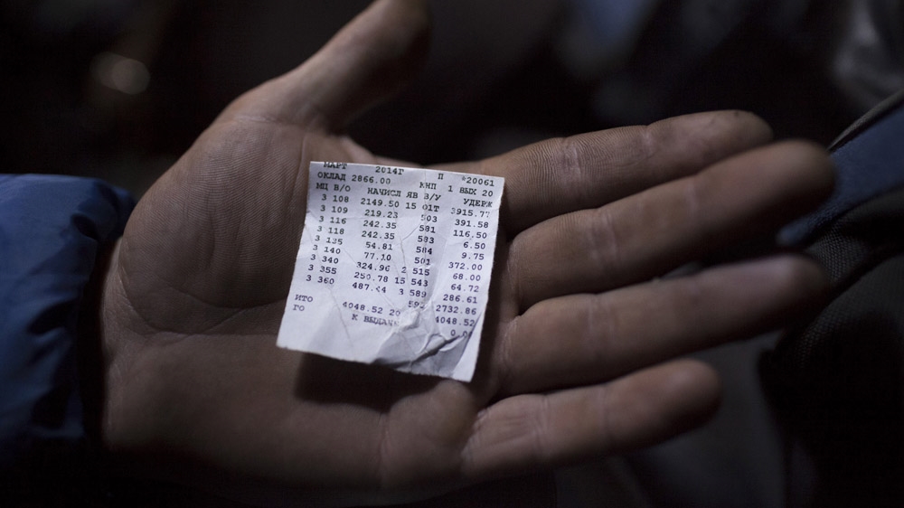 A miner in Krasnodon shows his last monthly paycheque. It amounts to little more than 4,000 grivnas or $260. The cost of feeding a family can reach 5,000 grivnas or $330, and living costs keep rising, particularly since the events at Maidan have thrown the country into turmoil. [Janos Chiala and Tali Mayer/Al Jazeera] 