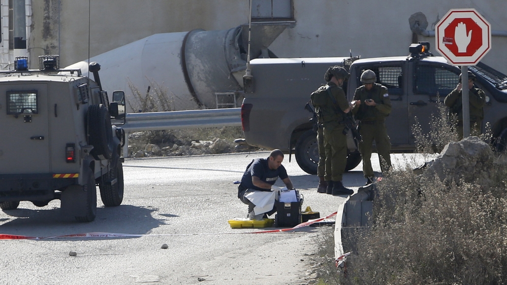 Israeli troops inspect scene where Palestinian, who the Israeli military said attempted to stab Israeli security forces with screwdriver, was shot dead at a checkpoint near Hebron
