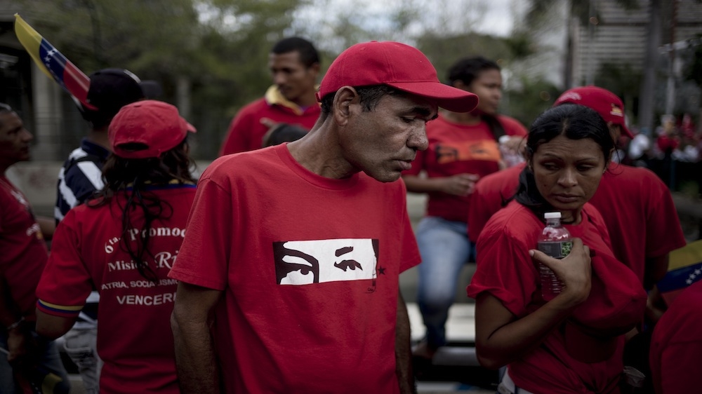 A man stands in the crowd during the closing rally of the ruling party [Alejandro Cegarra/Al Jazeera]