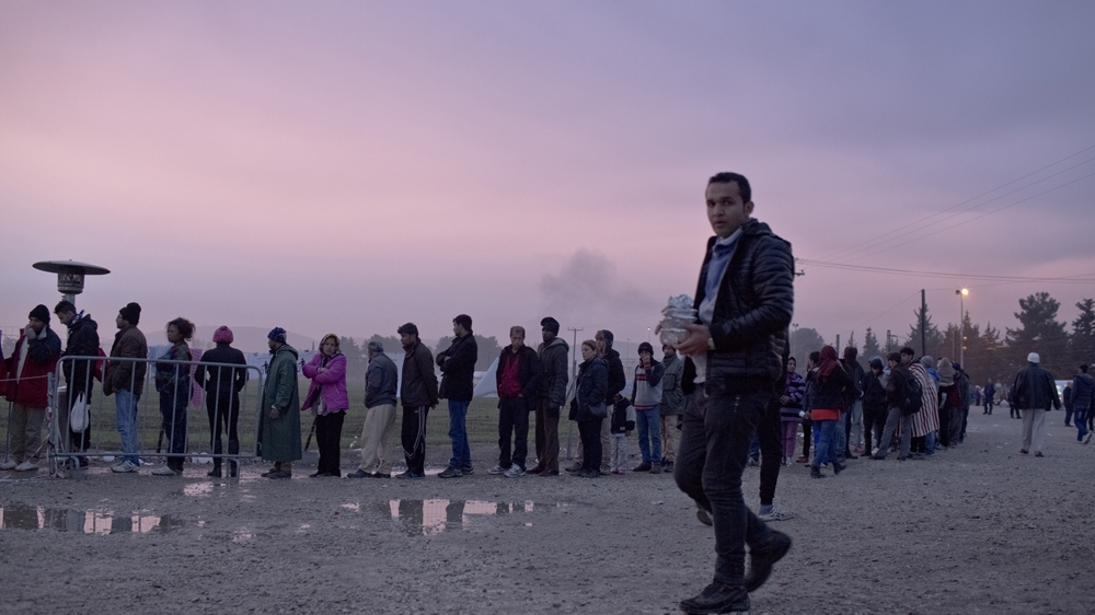 In the early morning hours, refugees stand in line for food provided by the NGO Praksis in Idomeni, Greece [Anna Psaroudakis/Al Jazeera]