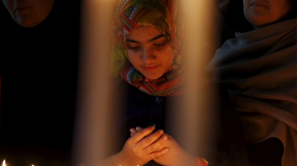 A girl prays for the victims of a militant attack on the Bacha Khan University, during a candle light vigil in Peshawar, Pakistan [REUTERS]