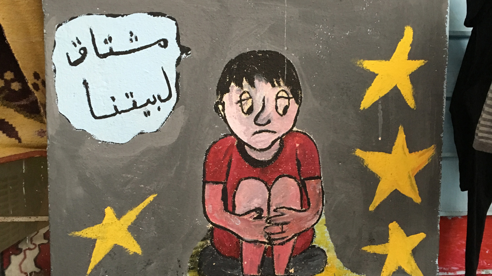 The text says, 'we miss our homes' [Mohammed Jamjoom/Al Jazeera]