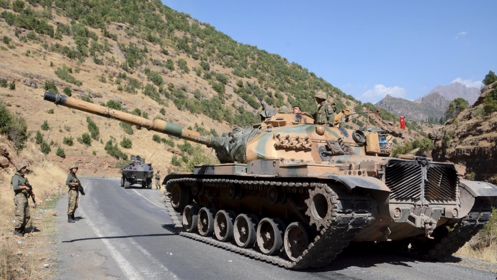 Turkish soldiers in a tank and an armored vehicle patrol on the road to the town of Beytussebab in the southeastern Sirnak province, Turkey
