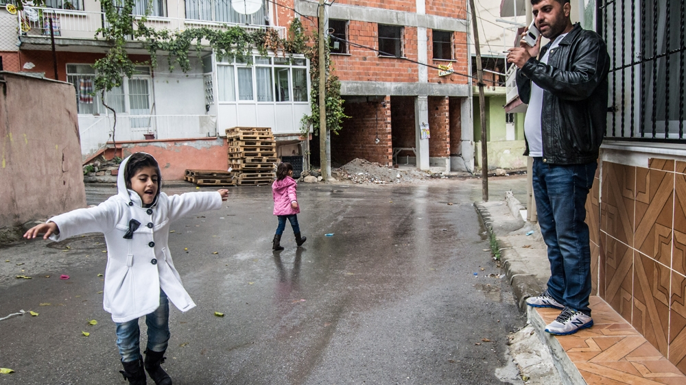 Roliana sings in the rain on the way to the smuggler's home where her father Delvan is going to make a deal [Pieter Stockmans/Al Jazeera]
