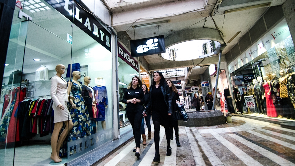 A group of young women walk past the 'Hillary 2' store, in a shopping mall built during the former Yugoslavia in the early 1970s [Valerie Plesch/Al Jazeera]