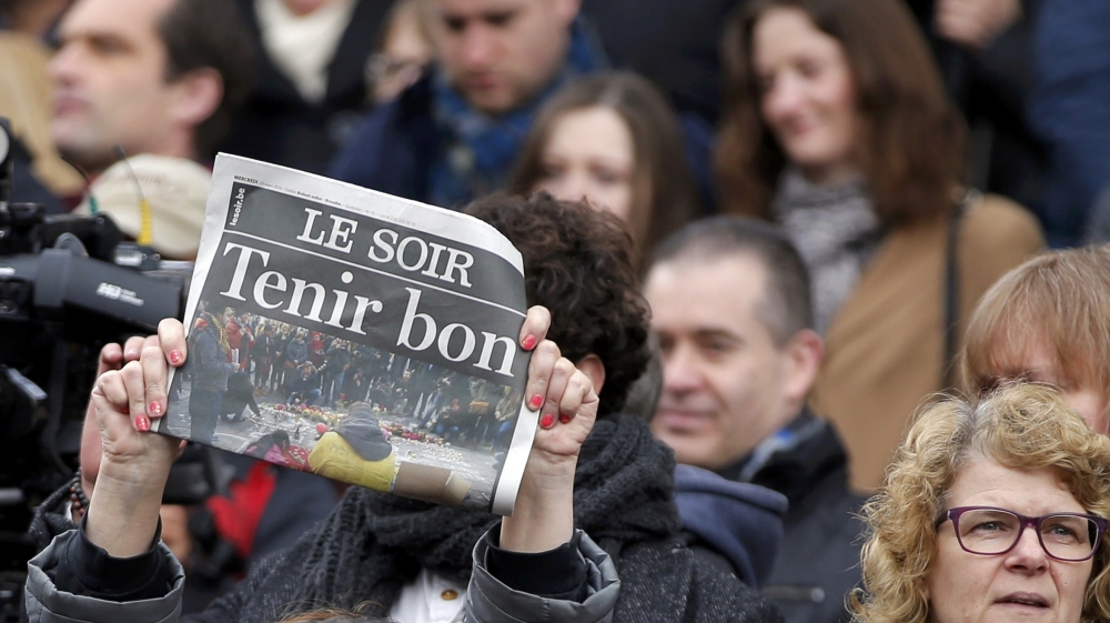 A newspaper is held up following a minute silence for victims of bomb attacks in Brussels, Belgium