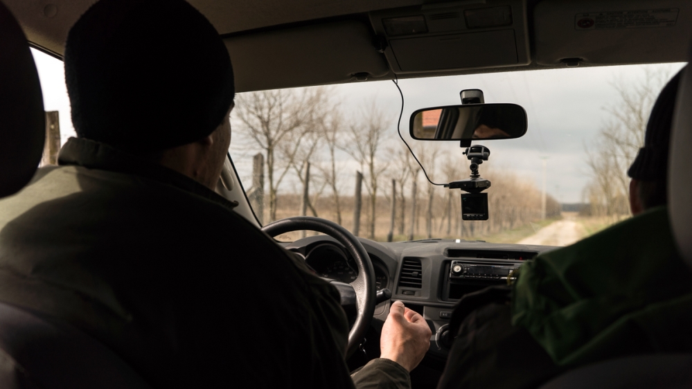 A village patrol officer driving along the border fence [Sorin Furcoi/Al Jazeera]