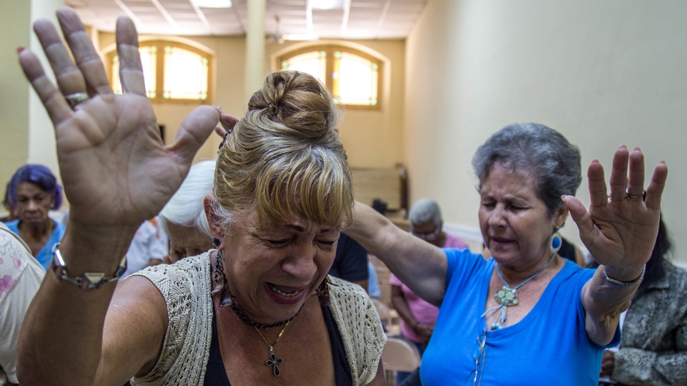 A prayer service reaches a crescendo at the First Baptist Church in Old Havana. The women ask God to save the 'lost youth' of Cuba [Tomas Ayuso/Al Jazeera] 