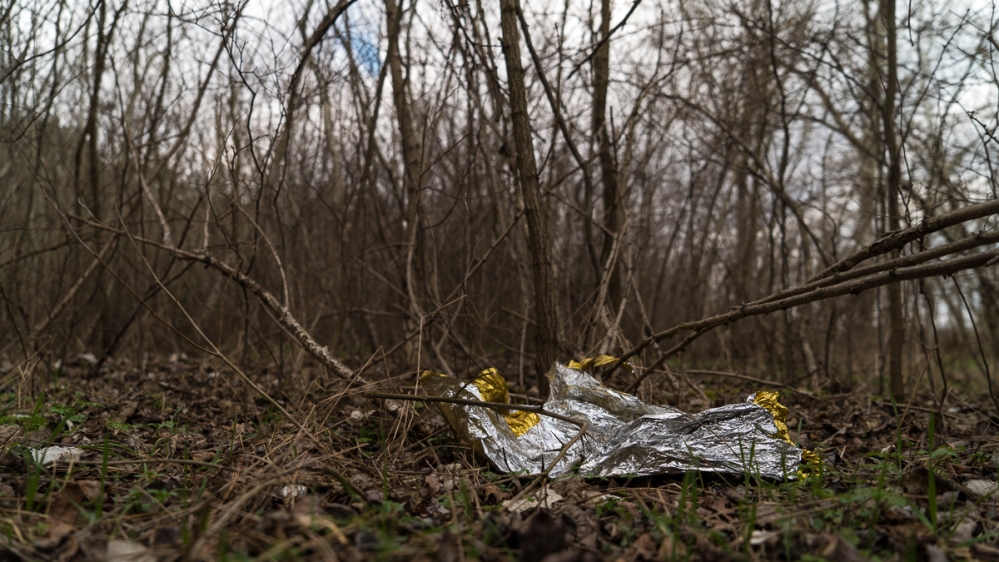 Sleeping bags, blankets and embers of campfires are all refugees leave behind as they move forward on their journey [Sorin Furcoi/Al Jazeera]
