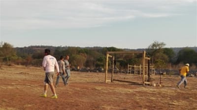 Victor Sandoval Escalante, 22, [centre, in the striped shirt] plays football with residents of the CeVIDA recovery clinic [Tim MacGabhann/Al Jazeera]