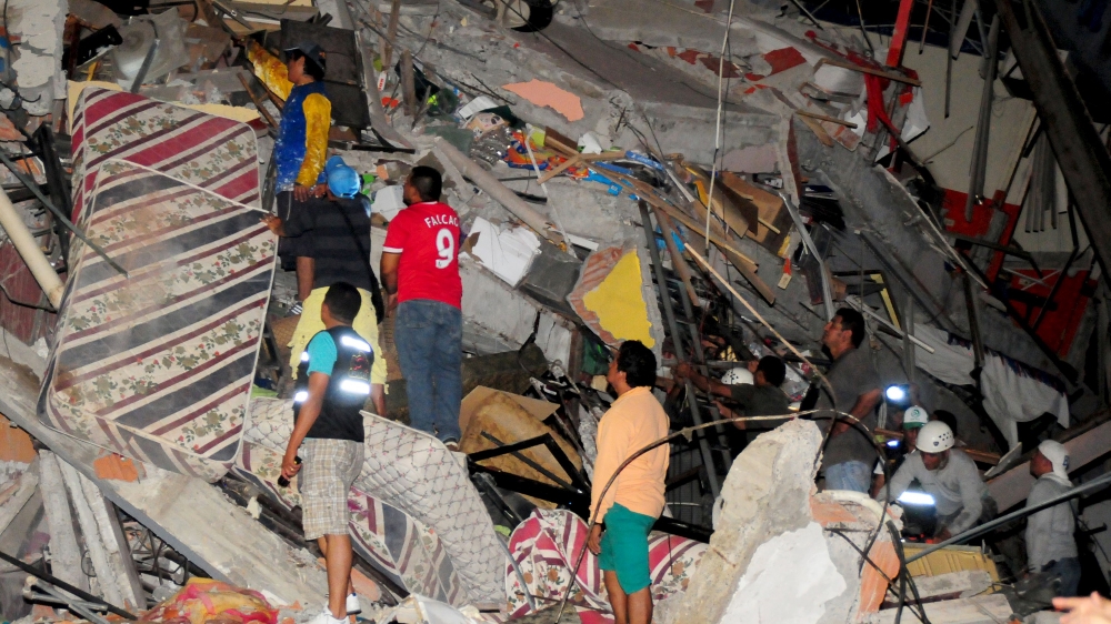 People stand on the debris of a building after an earthquake struck off the Pacific coast in Manta