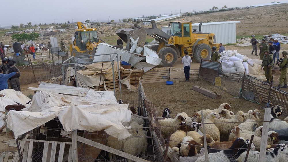 An Israeli bulldozer destroys one of six homes in the Bedouin community of Umm al-Khair [Tariq and Eid Hathaleen/Al Jazeera]