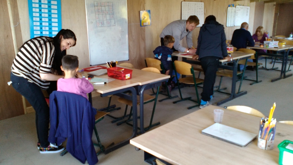 One of the Kurdish teaching assistants talks with a pupil. Several women have reported benefits to their mental health as a result of teaching [Jessica Staufenberg/Al Jazeera]
