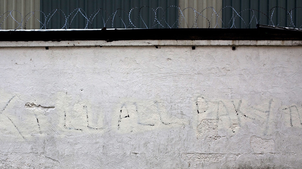 Racist graffiti has been partially scrubbed from a wall in the town [David Shaw/Al Jazeera]