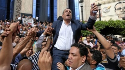 Journalists carry Yehia Kalash, head of the Egyptian press syndicate, during a protest against restrictions on the press in front of the Press Syndicate in Cairo [Reuters]