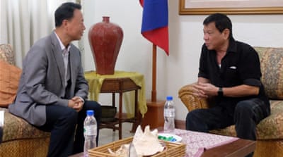 Duterte (right) talking to Chinese envoy Zhang Jianhua during a meeting in Davao City, southern Philippines, June 2 [EPA]