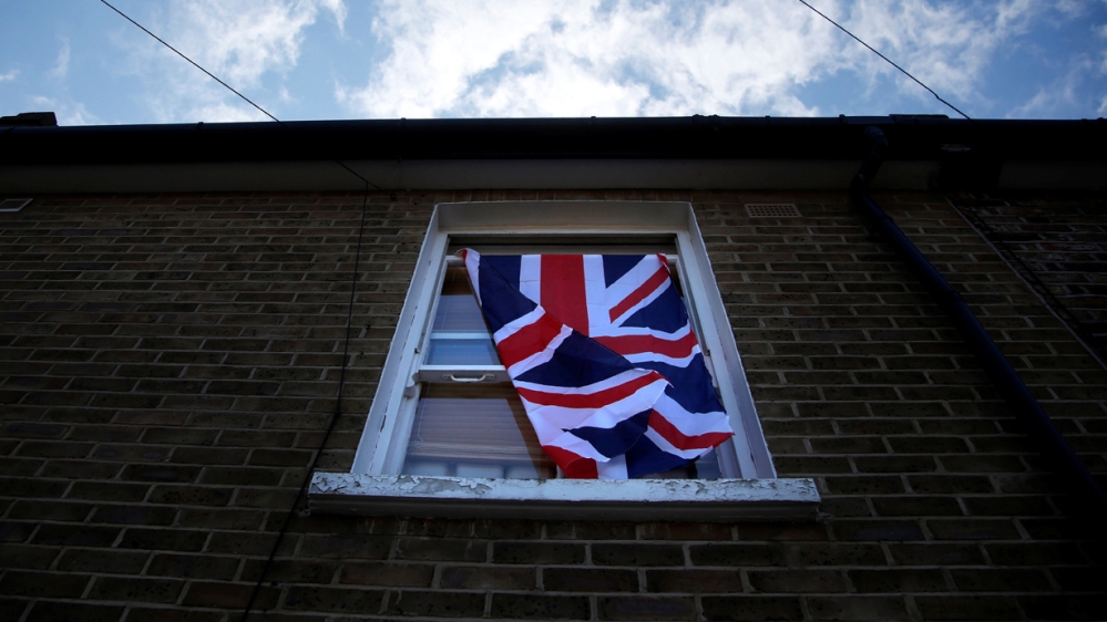 A British flag flutters in front of a window in London