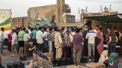 Refugees from Afghanistan and Syria wait for food handouts at the temporary tent camp in the Athens port of Piraeus [Iason Athanasiadis]