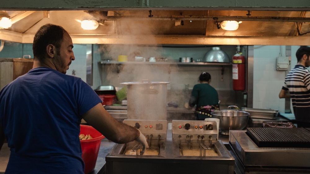 Several of City Plaza's residents prepare the food for iftar, when Muslims break their fast [Nick Paleologos/SOOC/Al Jazeera]