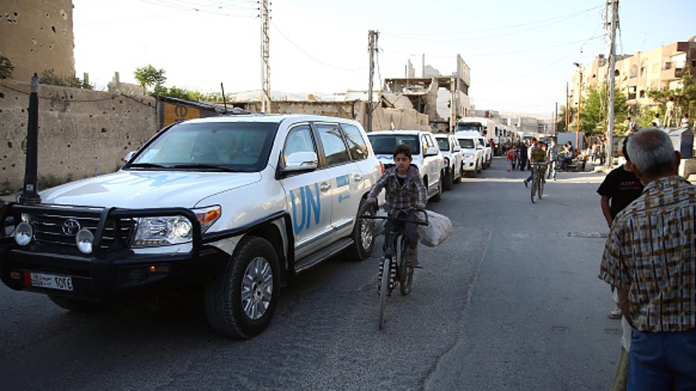 Vehicles of a UN and SARC aid convoy, with food, nutrition, health and other emergency items, enter the rebel-held town of Douma, east of the Syrian capital Damascus [AFP]