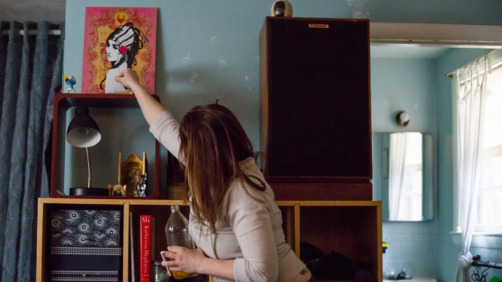  Becca puts out some incense she has been burning [Carolyn Bick/Al Jazeera] 