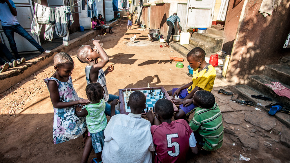 Children gather to watch a chess match after school in Katwe, where much of the upcoming movie was filmed [Aurelie Marrier d'Unienville/Al Jazeera]