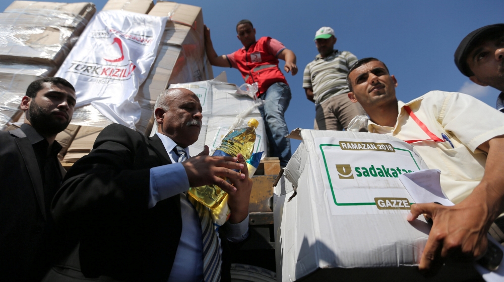 Palestinians unload Turkish aid shipments upon arrival in the Gaza Strip at Kerem Shalom crossing between Israel and southern Gaza Strip