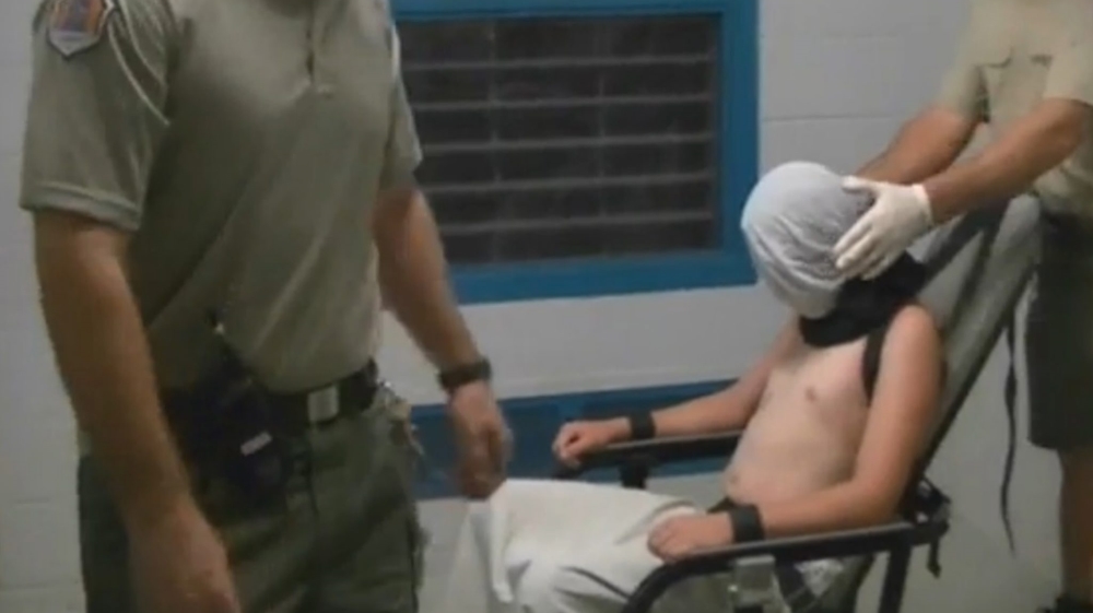CCTV footage from the Don Dale Youth Detention Centre shows a boy hooded and strapped to a mechanical chair [EPA]