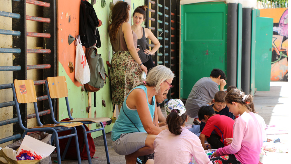 Volunteers play with children at the Fifth High School of Exarcheia [John Psaropoulos/Al Jazeera]