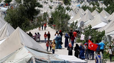Syrian refugees stroll at a refugee camp in Osmaniye