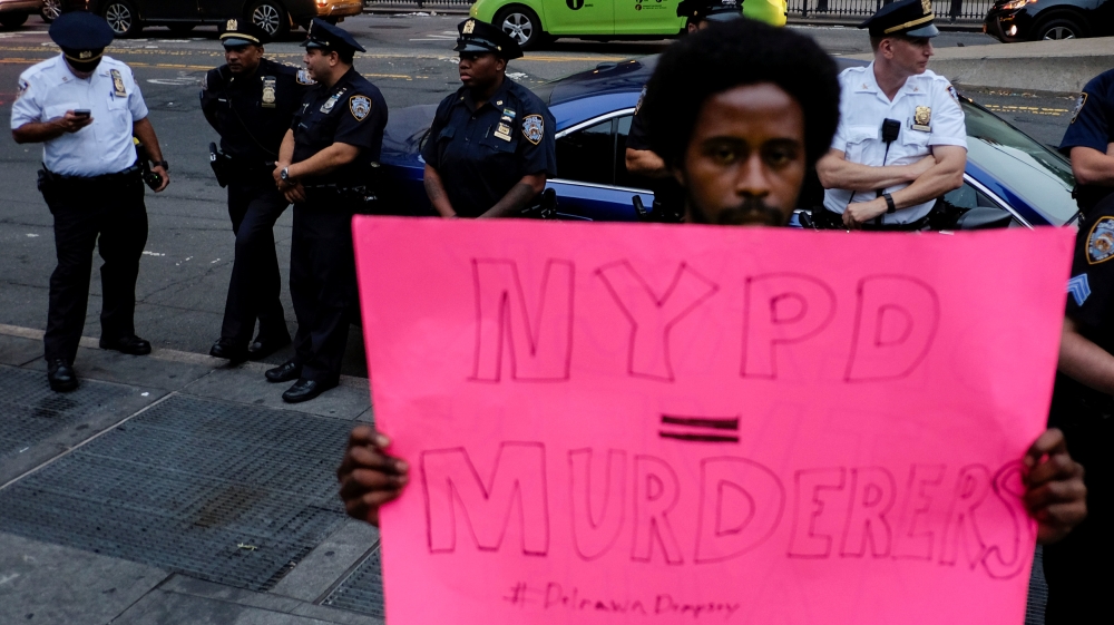 NYPD officers wait for the start of a march while people take part in a protest against police brutality and in support of Black Lives Matter in New York
