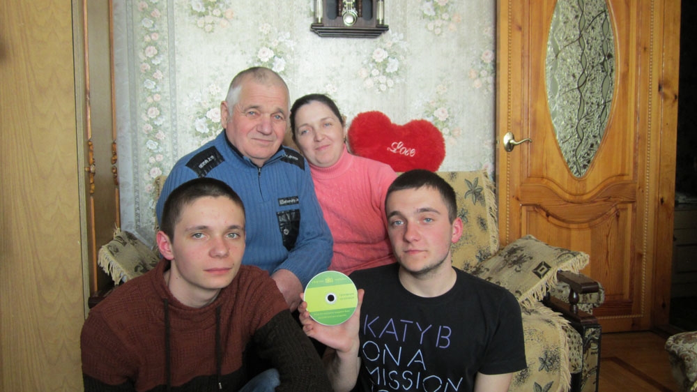  Lyudmila Kaminska with her father and sons Sergei, left, and Andrei, right, display a warning video they received from a collection agency, at their home in Vinnytsia [Chris Scott/Al Jazeera] 