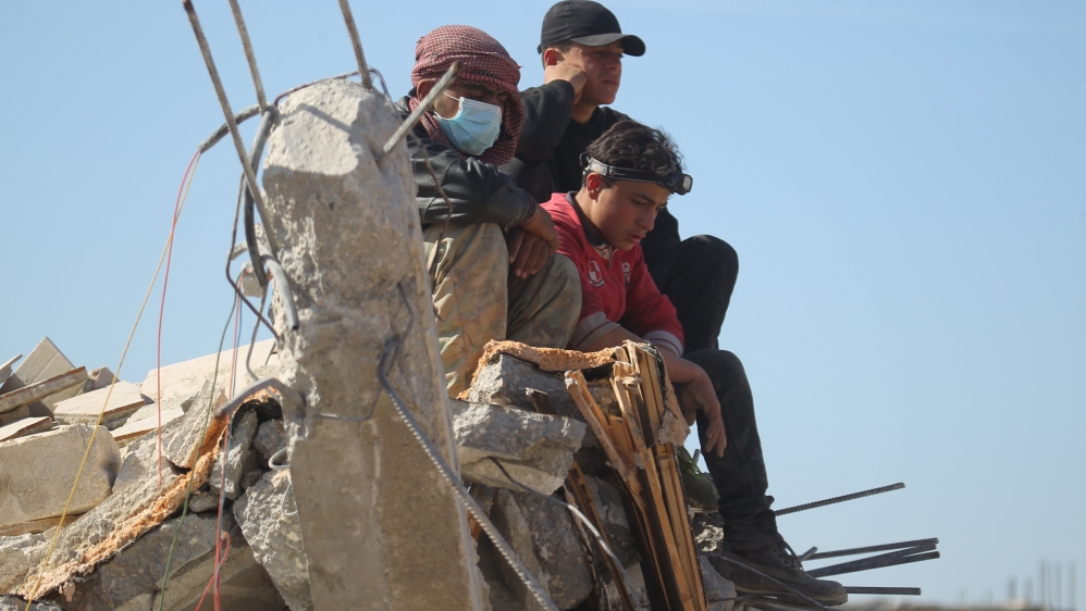 People rest in the ruins of a destroyed Medecins Sans Frontieres (MSF) supported hospital hit by missiles in Marat Numan, Idlib province, Syria