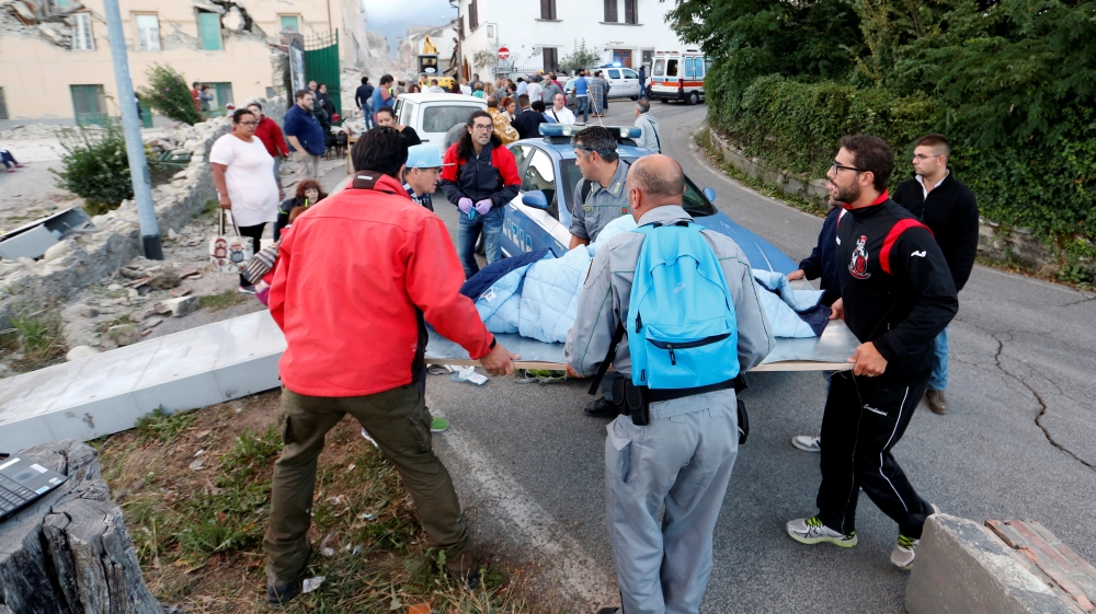 Rescuers lift an injured victim after the 6.2 magnitude earthquake [Remo Casilli/Reuters]