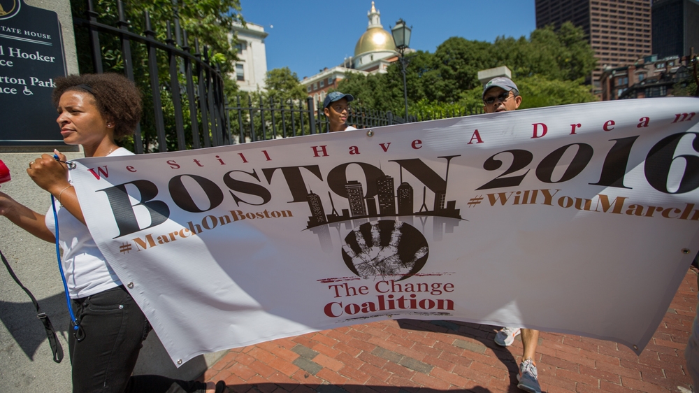 Lindsay Ladd, left, holds The Change Coalition's sign, as the group marches down the Freedom Trail [Carolyn Bick/Al Jazeera] 