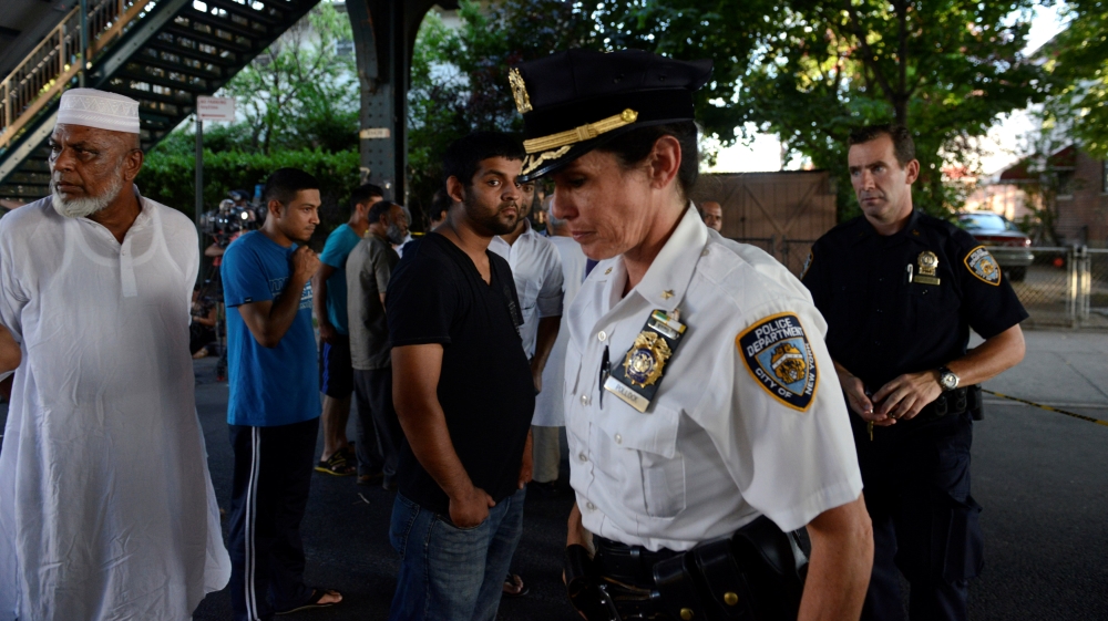Community members gather at the spot where Imam Maulama Akonjee was killed in the Queens borough of New York City