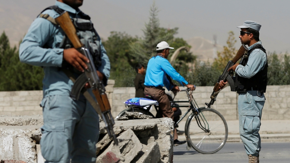 Afghan policemen stand guard at a checkpoint near the site of kidnapping in Kabul,