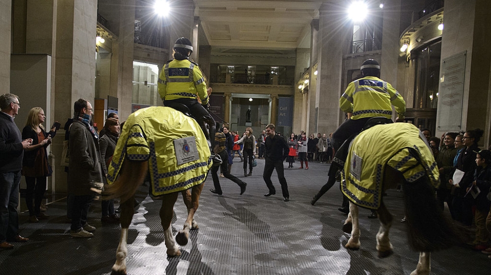Visitors and mounted police officers participate in Bruguera's performance Tatlin's Whisper #5 at the National Museum Wales in Cardiff on November 26, 2012 [Getty Images]