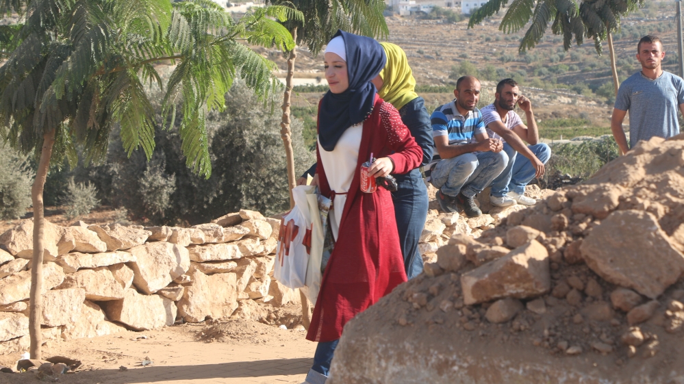 Palestinian women cross by foot through the blockaded main entrance to Bani Naim [Ylenia Gostoli/Al Jazeera]
