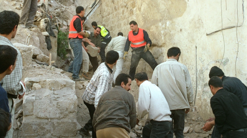 The al-Shobi family home in Nablus after it was razed to the ground by CAT bulldozers in Aprill 2002. Rescue workers and neighbours search under the rubble for Mahmoud's family [Nazeeh Darwazeh/The Associated Press]